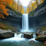Cascade de la Vis en Cévennes entourée de forêts de châtaigniers en automne, eau cristalline sur roches calcaires moussues