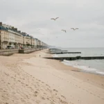 Vue panoramique du littoral des Hauts-de-France avec des hôtels en bord de mer et une plage de sable sous un ciel nuageux