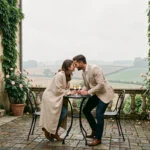 Couple romantique sur la terrasse d'un hôtel de charme dans le Nord de la France, entouré de roses et d'architecture en pierre
