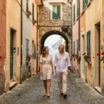 Ruelle pavée du centre historique de Monterosso al Mare avec maisons colorées et couple en promenade